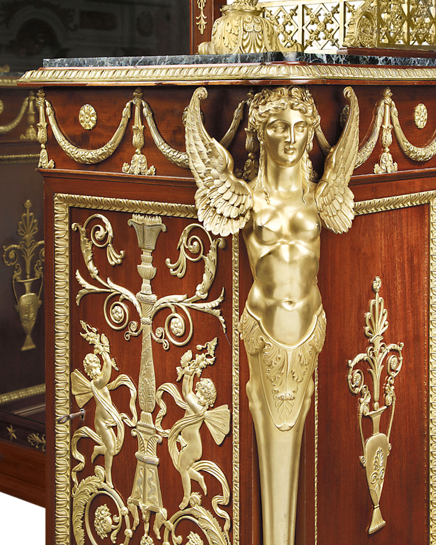 Bronze legs of winged creatures support the vanity and nightstand