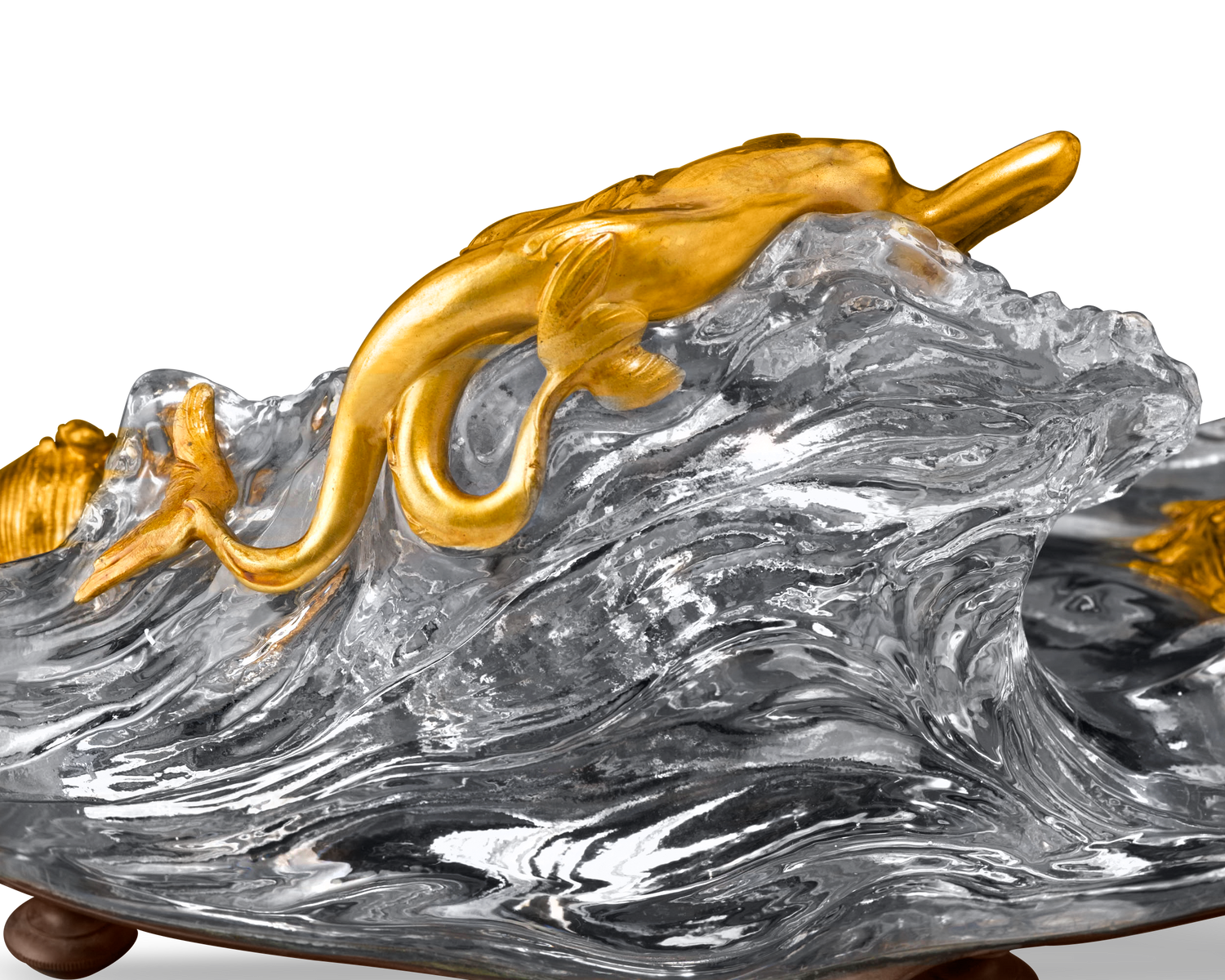 A seductive doré bronze mermaid reclines atop the crystal wave