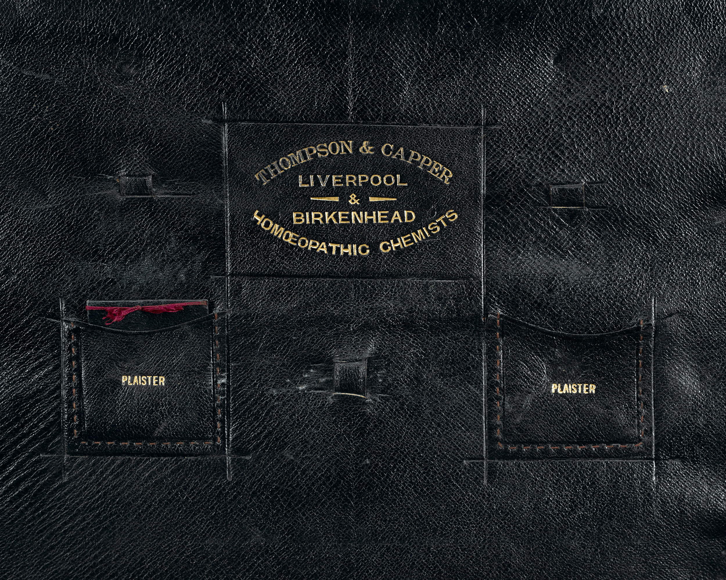 The interior lid bears the firm's mark